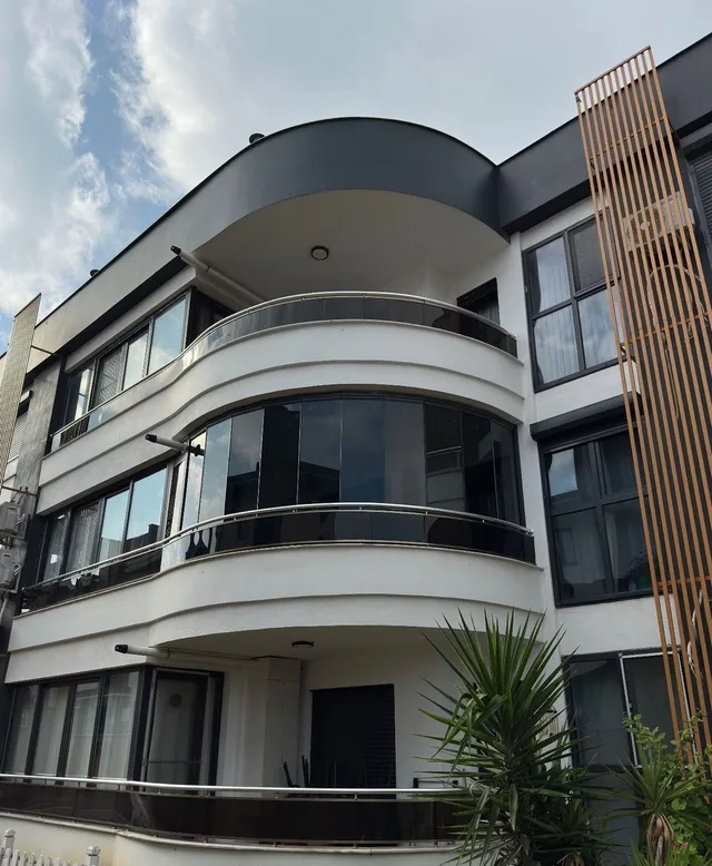 Karaali'de kavisli cepheye özel üretilen 8 mm temperli oval cam balkon uygulaması